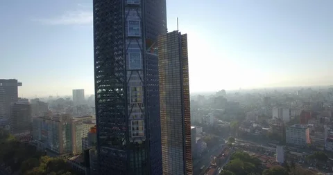 An aerial shot elevates along the Bancomer Tower in Mexico city revealing the Video stock 126047974