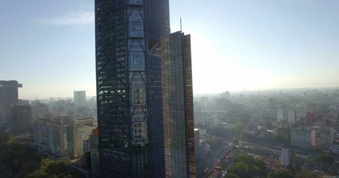 An aerial shot elevates along the Bancomer Tower in Mexico city revealing the Video stock 126048656