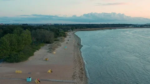 Aerial shot of an empty beach after sunset with changing cabins and benches Stock Footage 98373713