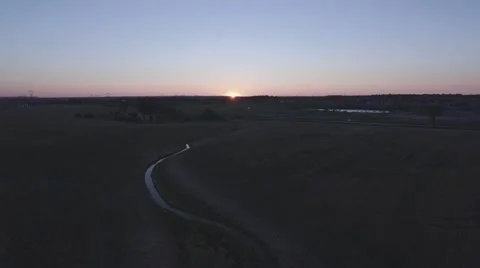 Aerial shot of empty field pulling out during sunset Stock Footage 60133505