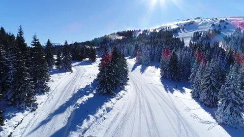 Aerial shot of empty ski slopes and a cabin in the snowy mountains Stock Footage 86078594