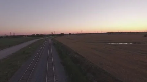Aerial shot empty train track camera pulling back during sunset Stock Footage 60133289