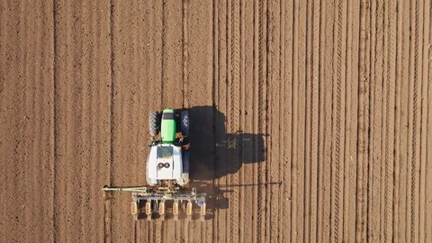 Aerial shot of a farmer seeding, sowing crops at field. Stock Footage 90974553