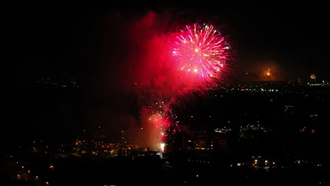 Aerial Shot Of Fireworks Exploding Against Sky At Night, Drone Flying Backward Stock Footage 243883494