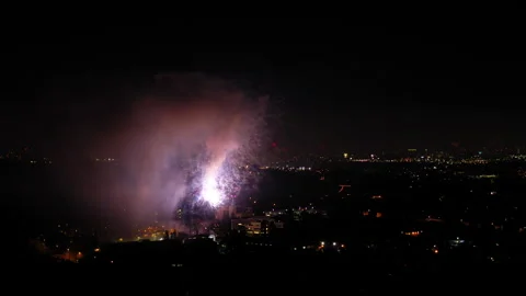 Aerial Shot Of Fireworks Exploding On City Against Sky At Night, Drone Flying Stock Footage 244024009