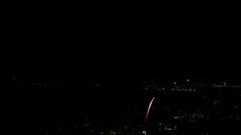 Aerial Shot Of Fireworks Exploding On Cityscape Against Sky At Night, Drone Stock Footage 243884978