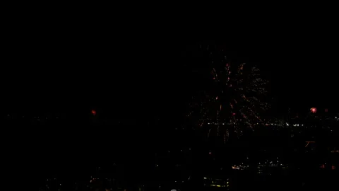 Aerial Shot Of Fireworks Exploding In Neighborhood Against Sky At Night, Drone Stock Footage 243881144
