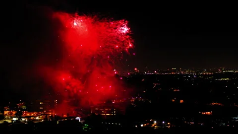 Aerial Shot Of Fireworks Exploding In Neighborhood Against Sky, Drone Flying Stock Footage 243883436