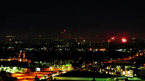 Aerial Shot Of Fireworks Exploding Over Buildings In City, Drone Flying Forward Stock Footage 243878487