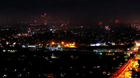 Aerial Shot Of Fireworks Exploding Over Buildings In City Against Sky, Drone Stock Footage 243882899