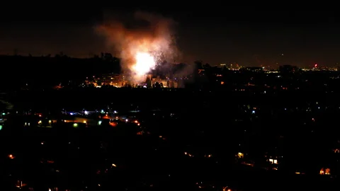 Aerial Shot Of Fireworks Exploding Over Neighborhood In City, Drone Flying Stock Footage 243884242