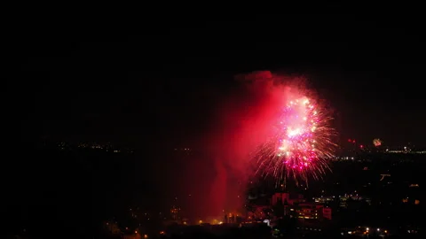 Aerial Shot Of Fireworks Exploding Over Buildings In City Against Sky, Drone Stock Footage 244016406