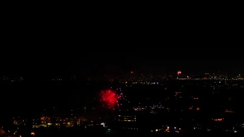Aerial Shot Of Fireworks Exploding On Residential Buildings Against Sky, Drone Stock Footage 243883499