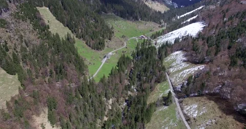 Aerial shot of a flight through a valley in the direction of a hut Stock Footage