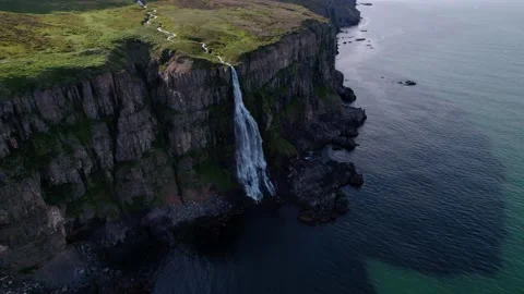 Aerial shot of flowing waterfall on the side of a cliff into ocean, Iceland. Video stock 166309682