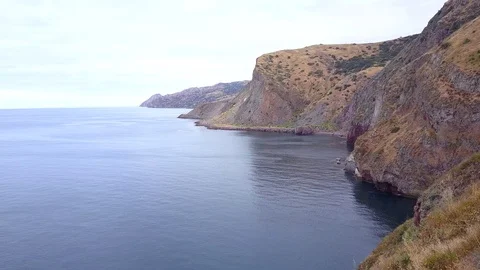 Aerial shot flying backwards from the edge of a cliff revealing a fence. 库存影片 88672736