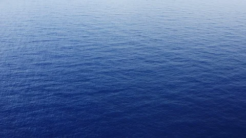 Aerial shot flying over endless tropical blue ocean background Stock Footage