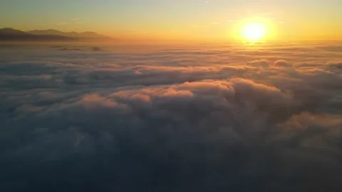Aerial shot of flying over a layer of clouds at sunrise Stock-Footage 200958599