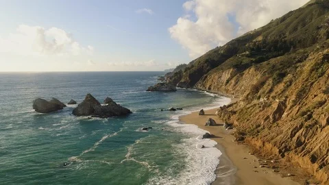 Aerial shot flying over a pristine sandy beach on a rugged coastline. Epic views Video stock 88163096