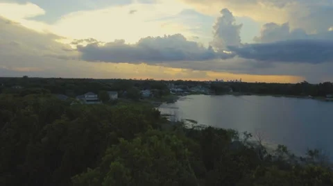 Aerial shot flying over trees to view of Lake at Sunset Stock Footage 67548433