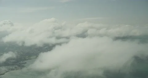 Aerial shot flying through the clouds with city and water below Stock Footage 145947113