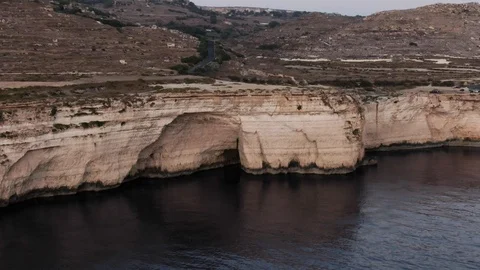 Aerial Shot flying towards a small Cave in Dingli Cliffs Stock Footage 113148375