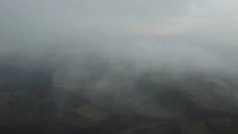 Aerial shot of forests and fields through the clouds Stock Footage 170766974