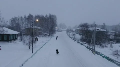 Aerial shot in forward movement over snowed town with road when snow-storm Stock Footage 166281553