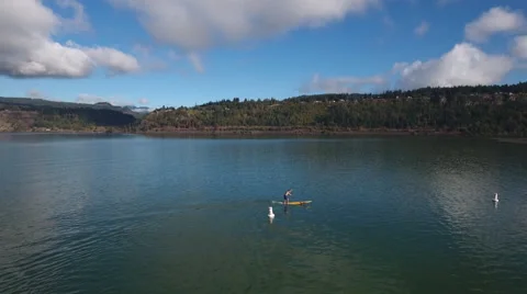 Aerial shot forward push / downward tilt of standup paddler going around bouie. Stock Footage 68626042