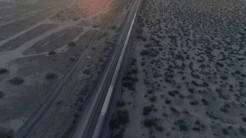 Aerial shot of a freight train crossing the desert at sunset, United States Stock Footage 127726329