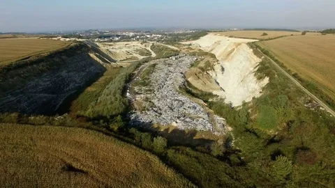 Aerial shot of garbage dump between agricultural fields. Video stock 80977719