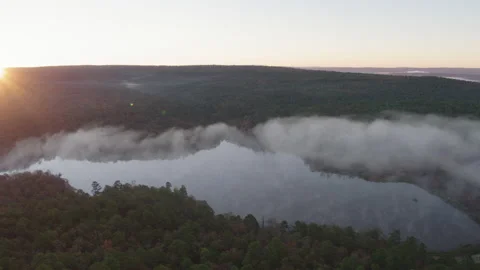Aerial Shot Gliding Over a Foggy Morning Forest as the Sun Rises Stock Footage