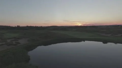 Aerial shot golf course camera raising up during sunrise Stock Footage 61114335