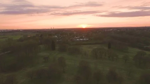 Aerial shot of green fields trees and orange red sunset sky Stock Footage 89049795