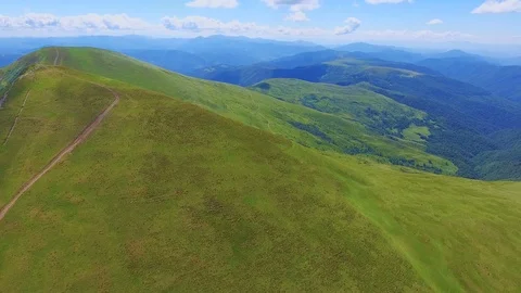 Aerial shot of a high mountain range with a lane in the Carpathians in summer Stock Footage 93639748
