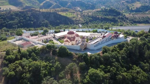 Aerial shot of a historic monastery surrounded by trees and mountains Stock Footage 344105335