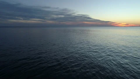 Aerial Shot Hovering Over the Ocean Waves at Sunset Stock Footage 136489127