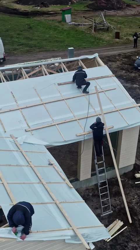 An aerial shot of how a group of workers is creating a wooden roof. They are Stock Footage 319294620