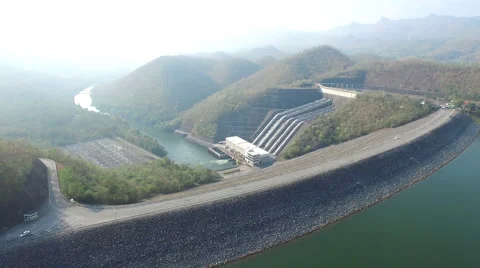 Aerial shot of a hydroelectric power station dam surrounded by mountain & street Stock Footage