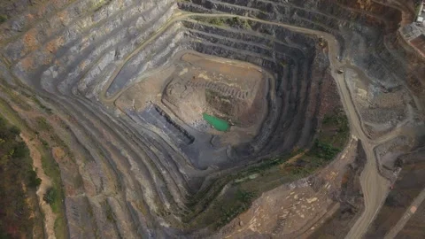 Aerial shot of an immense open-pit mine quarry with terraced walls Видео 343842826