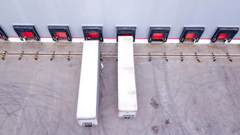 Aerial Shot of Industrial Warehouse Loading Dock where Many Truck with Semi T Stock Photos