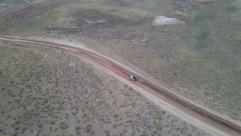AERIAL SHOT: Jeep driving on dirt road as drone follows behind. Stock Footage