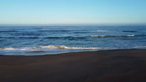 Aerial Shot to left over waves tracking single pelican - golden hour Stock Footage 161594920