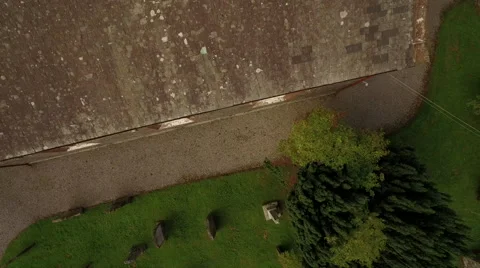 Aerial shot looking down on old churchyard and spiralling up Video stock 64634412