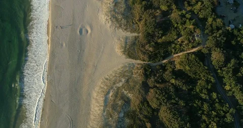 Aerial shot looking down on pristine Australian beach at sunrise Stock Footage 110886911