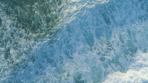 Aerial shot looking straight down at powerful ocean waves at sunset Stock Footage 103472812