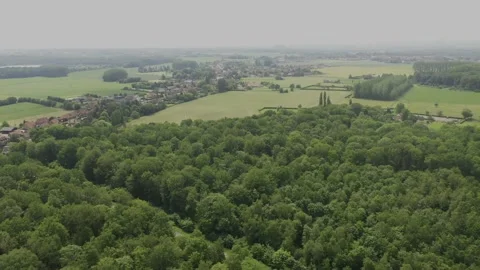 Aerial shot made by a drone of a forest and a village in Northern France Stock Footage 178994627