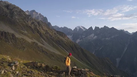 Aerial shot of a man going down the mountains on a sunny day in autumn or spring Video stock 99022067