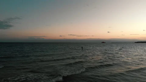 Aerial shot of man practicing paddle board at sunset on the ocean Stock Footage 169419631
