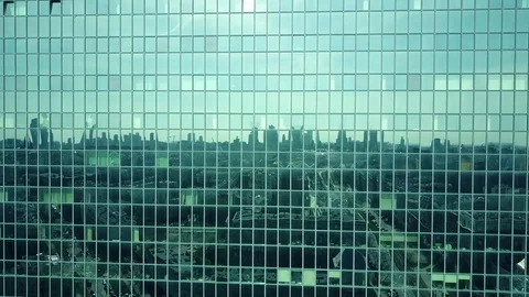 Aerial shot of modern office building windows reflecting cityscape on a sunny Stock Footage